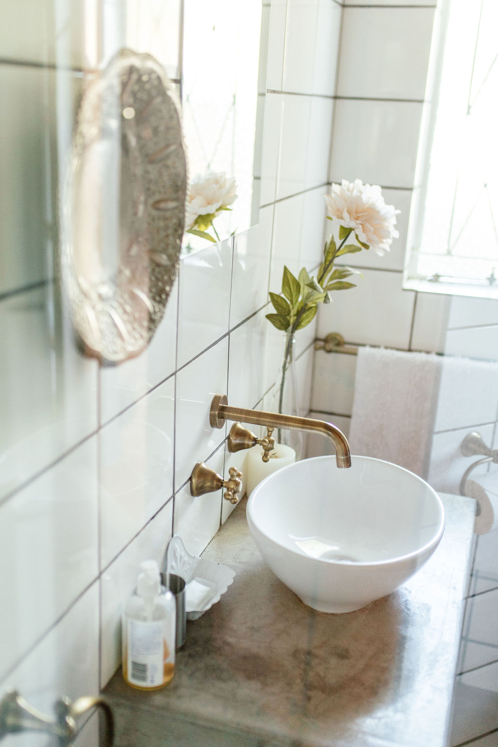Bathroom basin with brass taps and white tiles