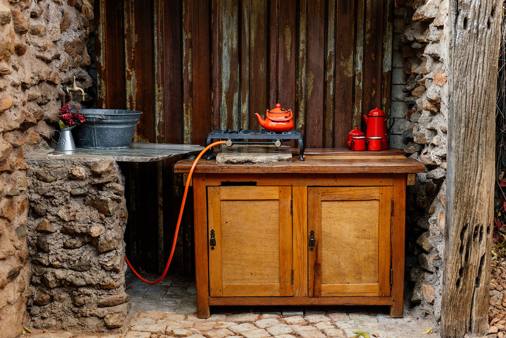 Outdoor kitchen corner with a gas stove and wooden cupboard